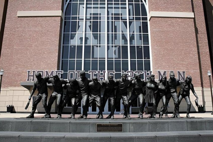 A statue of men in various poses in front of a building with 'HOME OF THE BRAVES' text. 1