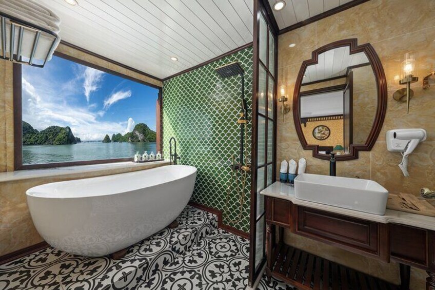 A bathroom with a large bathtub, a mirror, and a view of a body of water. 2