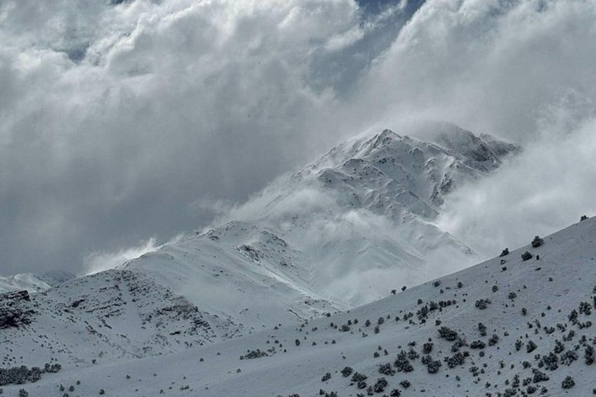 A snow-covered mountain range with clouds. 4