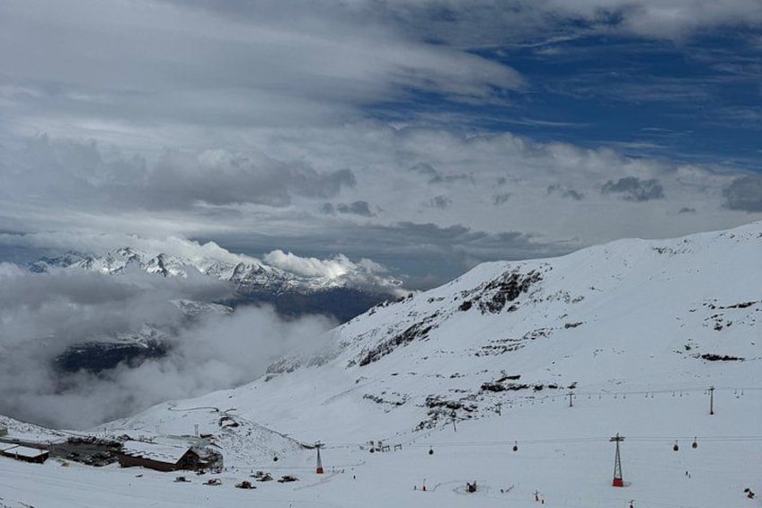 A snow-covered mountain landscape with ski lifts and a ski resort. 1