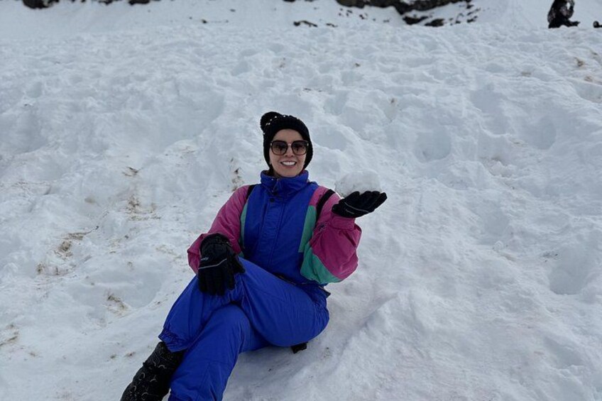 A person sitting on a sled in a snowy landscape. 3