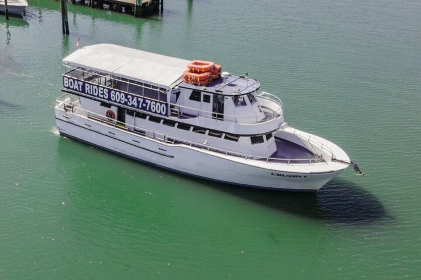 Una embarcación blanca con un cartel que dice 'BOAT RIDES 609-347-7600'. 1