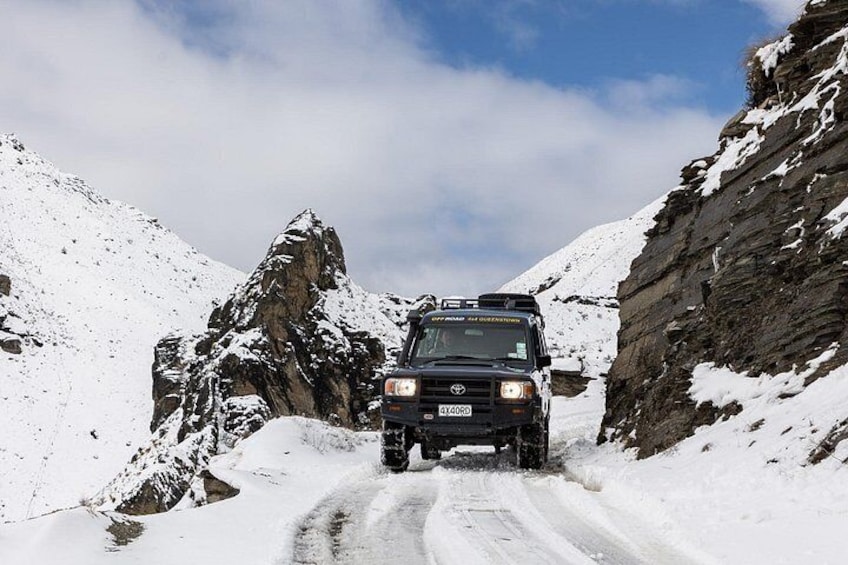 A vehicle on a snow-covered mountain road. 3