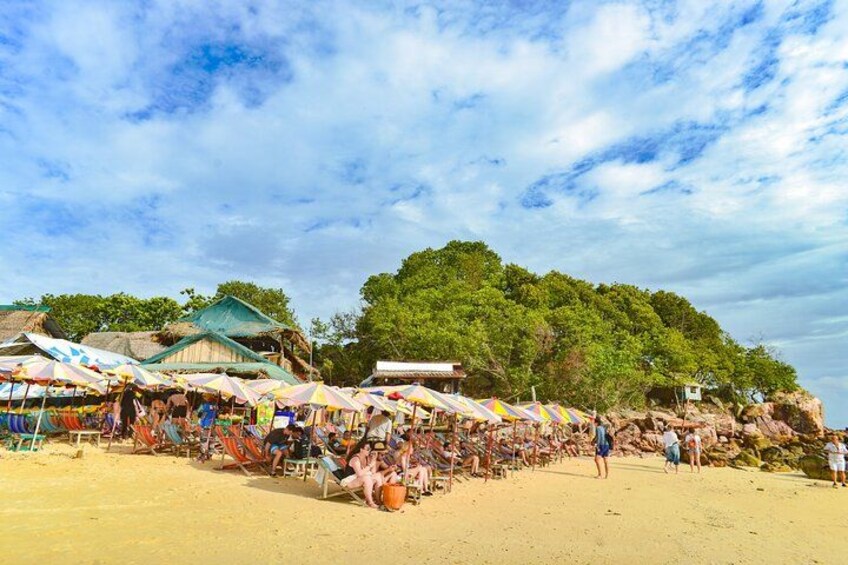 A beach with market stalls and people. 5