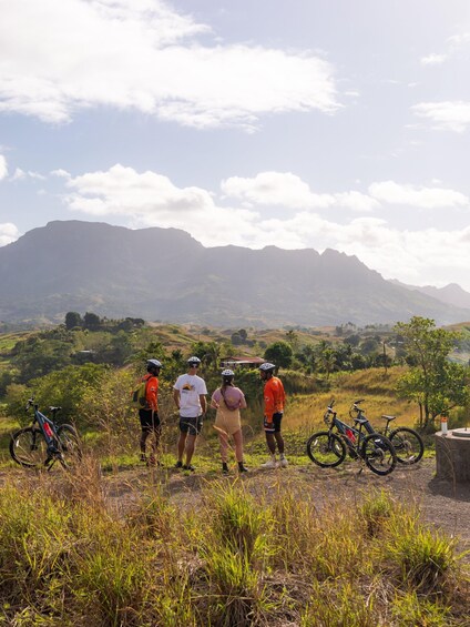A group of cyclists on a mountain trail with bicycles and a mountain in the background. 2