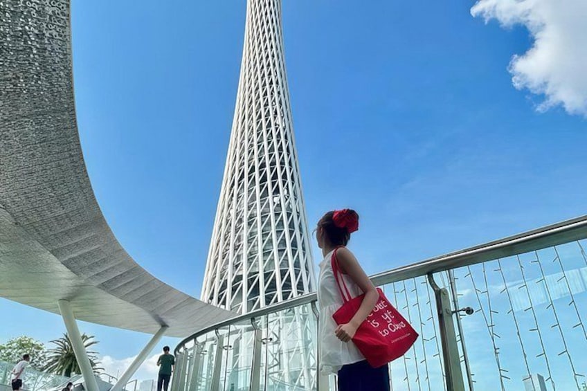 Una torre alta y esbelta con estructura de celosía, un dosel blanco curvo y un cielo azul despejado. 4