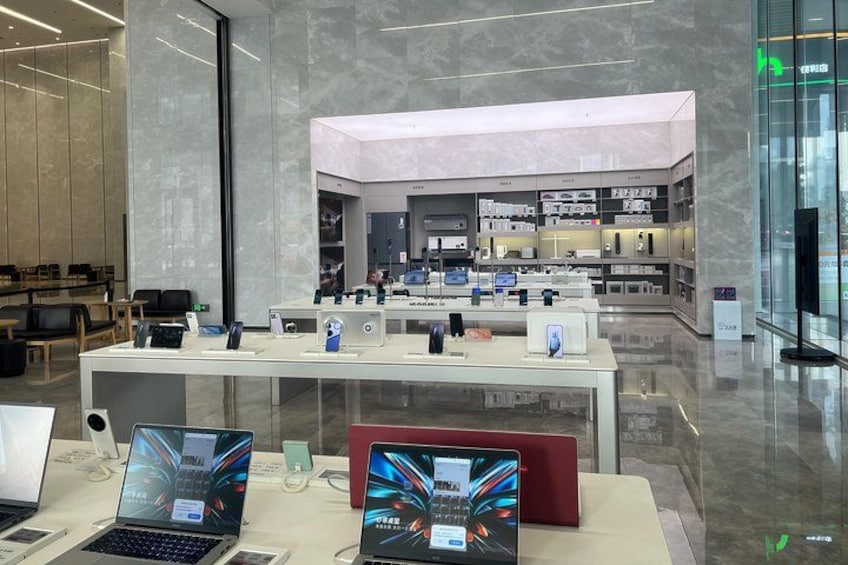 Una tienda moderna de electrónica con laptops y teléfonos inteligentes exhibidos. 2