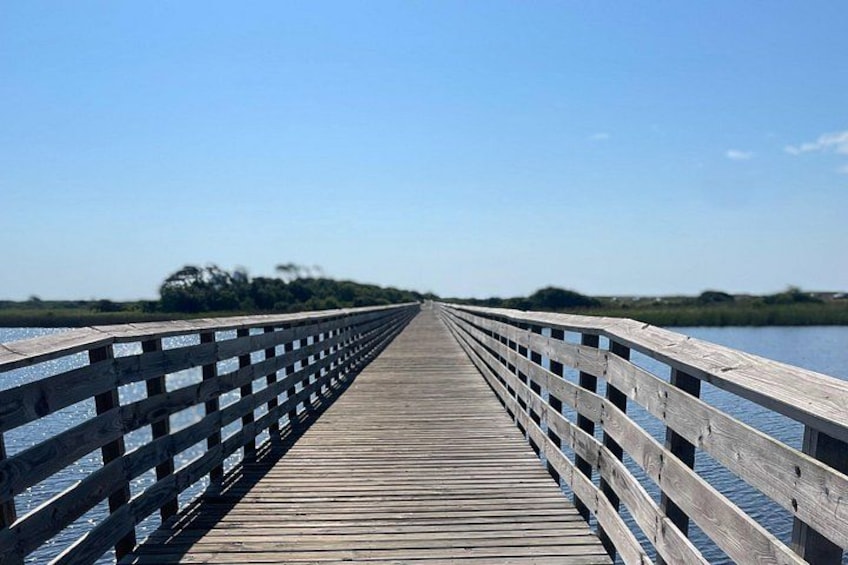 A wooden pier extending into a body of water with a clear sky above. 2