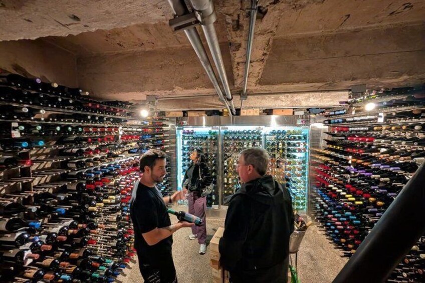 A wine cellar with rows of wine bottles. 5