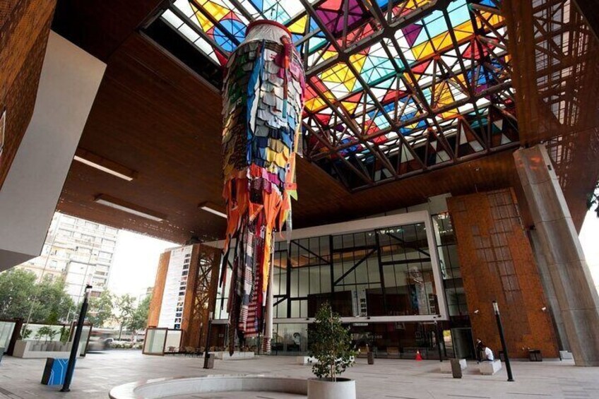 Un edificio moderno con un techo de vitrales coloridos y una estructura colgante decorativa. 4