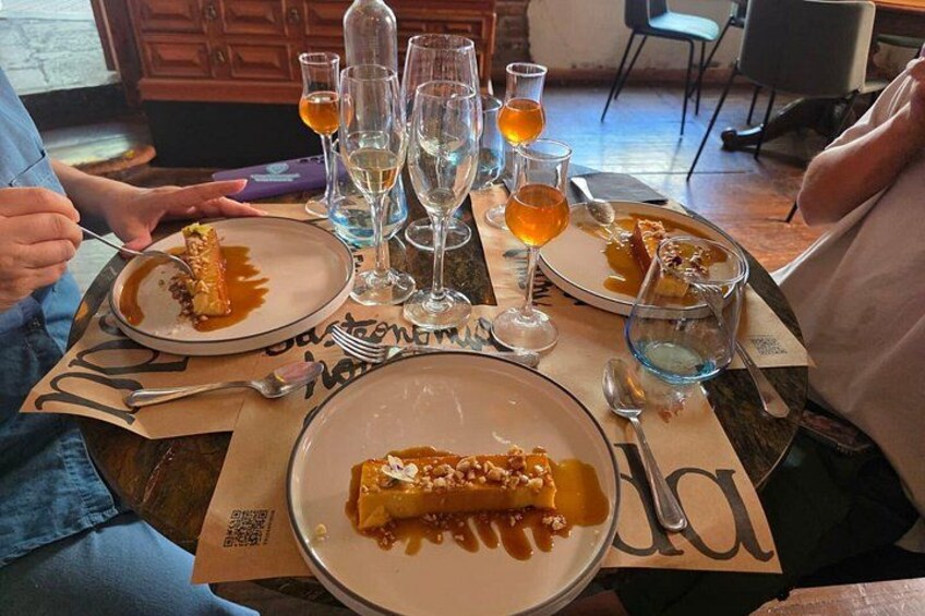 Un tavolo imbandito con piatti di cibo, bicchieri di bevande e un codice QR. 4