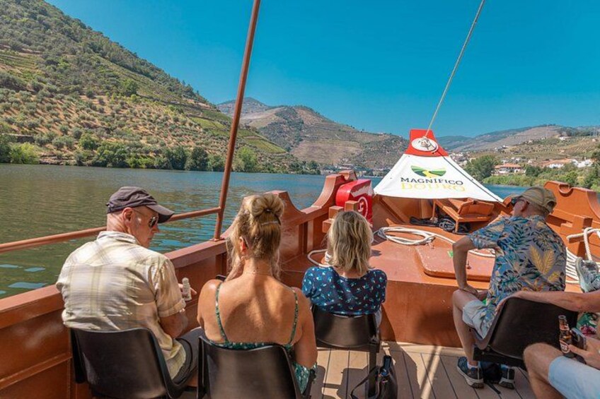 A boat with passengers enjoying a scenic view of a river and hills. 2