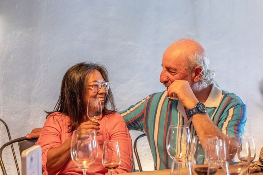 Two people sitting at a table with wine glasses. 4
