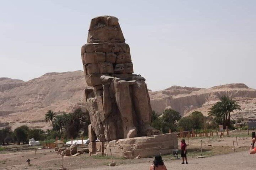 Un gran obelisco egipcio antiguo en un paisaje desértico, con montañas al fondo. 2