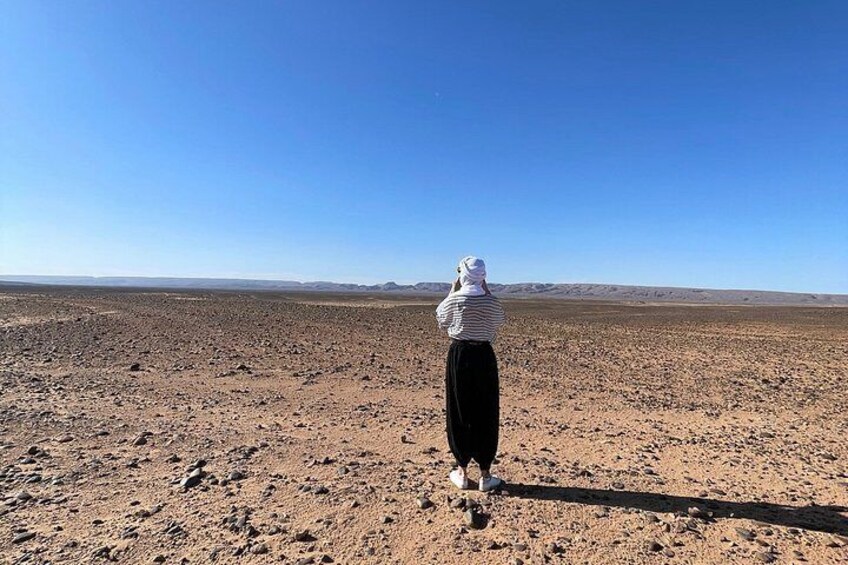 A person standing in a barren landscape with a clear sky. 2