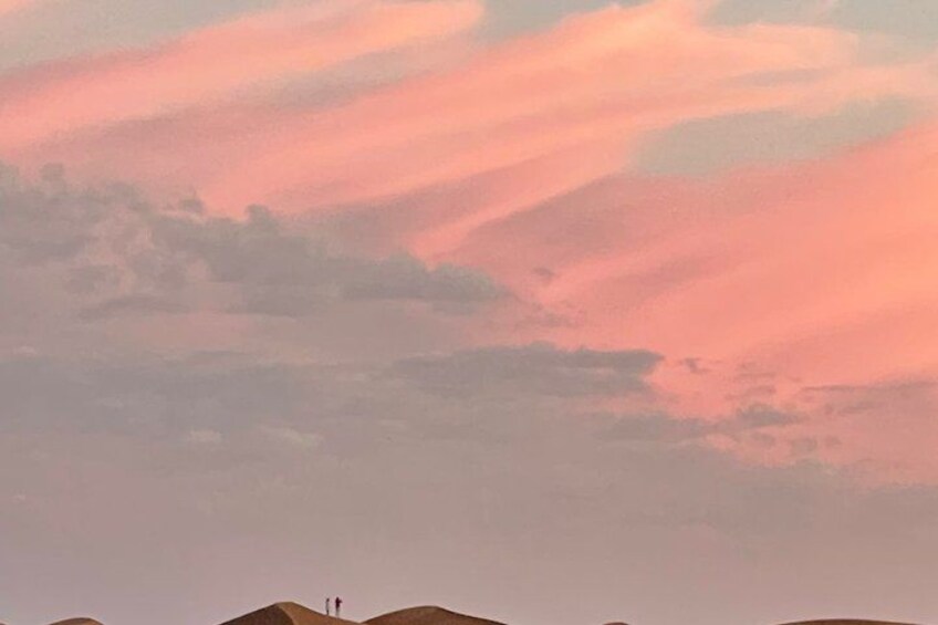 A sunset sky with pink and orange hues, a silhouette of a person, and a distant hill. 5