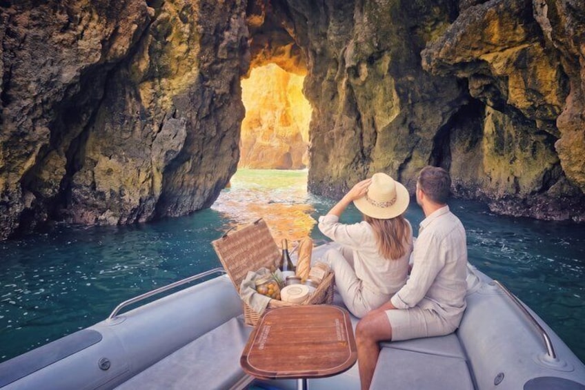 Un couple se trouve sur un bateau près de l’entrée d’une grotte, où l’on peut voir de l’eau qui s’écoule. 1