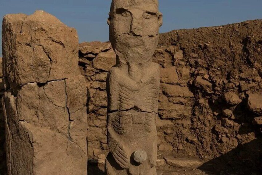 A large stone statue with intricate carvings, set against a rocky background. 4