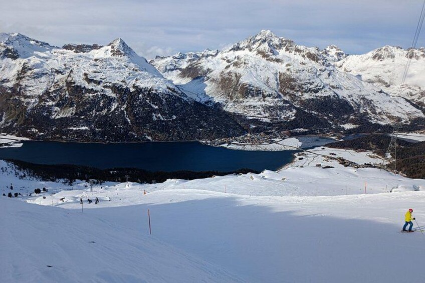 Un paysage de montagne enneigé avec un lac et un skieur. 3
