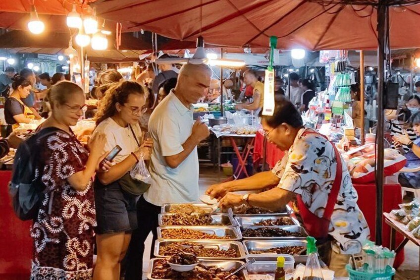 Ein belebter Nachtmarkt mit Händlern und Kunden. 2