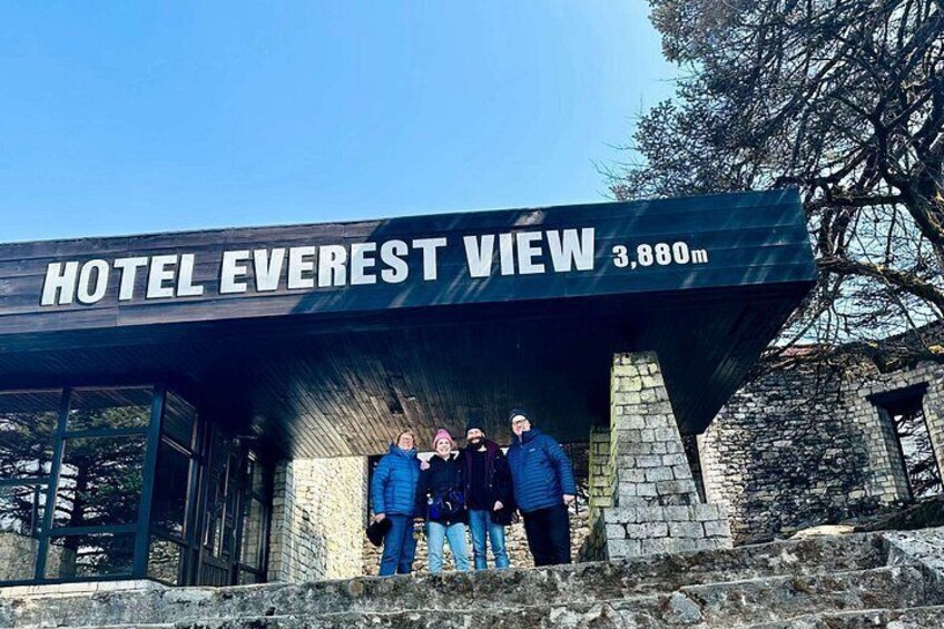 A sign for Hotel Everest View at 3,880m, with a stone structure and a clear sky. 3