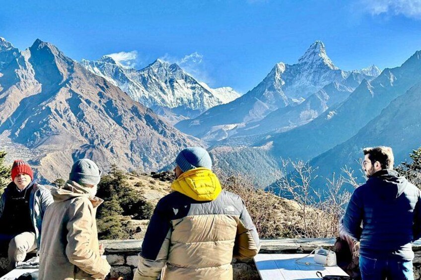 Un gruppo di persone in piedi su un crinale montuoso, con cime innevate sullo sfondo. 5