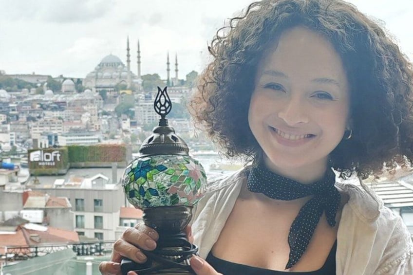 Eine Person hält eine dekorative Lampe, im Hintergrund ist eine Stadtansicht zu sehen. 4