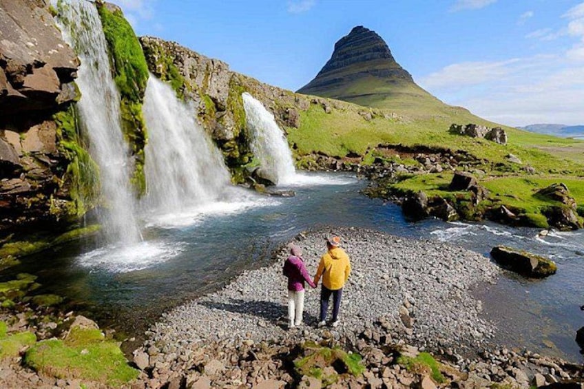 A waterfall, rocky terrain, and a mountain in the background. 2