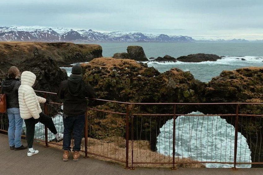 A coastal landscape with rocky outcrops and a glacier. 4