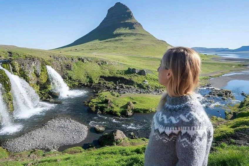 A waterfall, a grassy landscape, and a mountain. 4