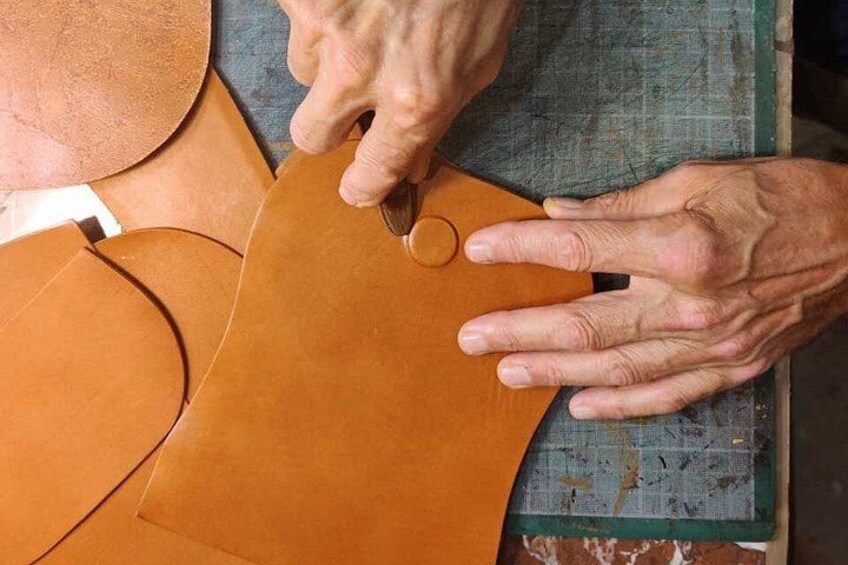 Manos trabajando con piezas de cuero, posiblemente en un proceso de artesanía o trabajo del cuero. 2
