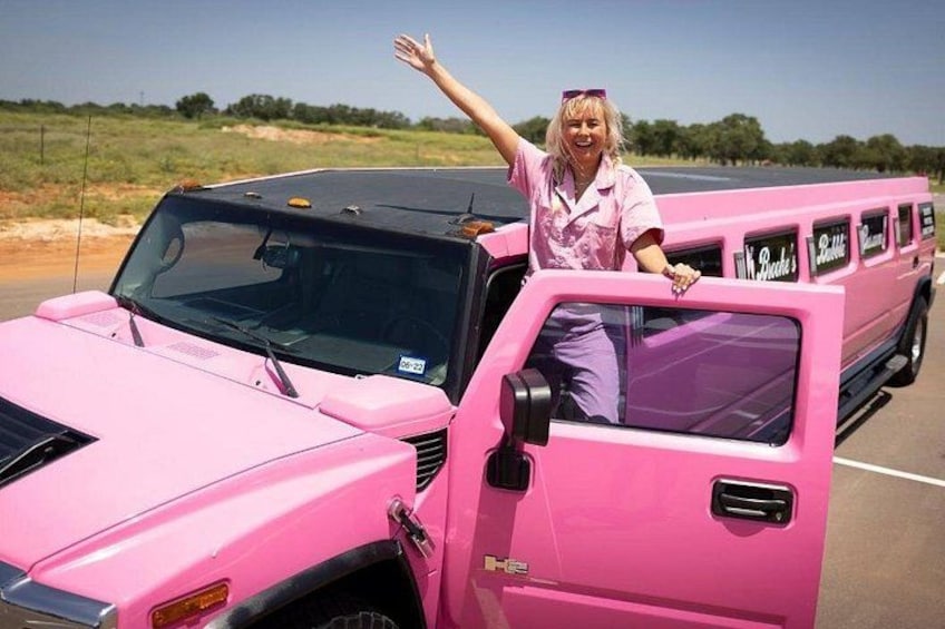 A pink vehicle with a person standing next to it. 1