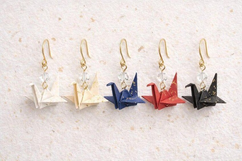Five pairs of earrings with origami designs in different colors. 5