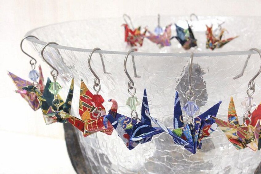 A collection of colorful origami birds on a glass surface. 1