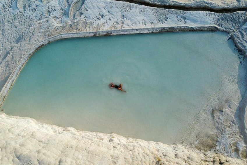 A person in a body of water surrounded by a rocky landscape. 5