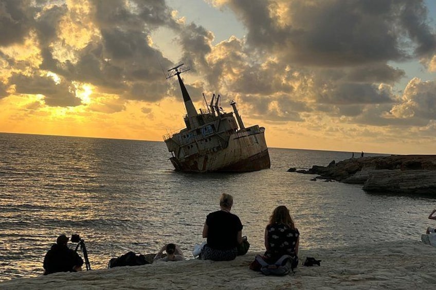 Et vrag på stranden med folk, der sidder i sandet. 2