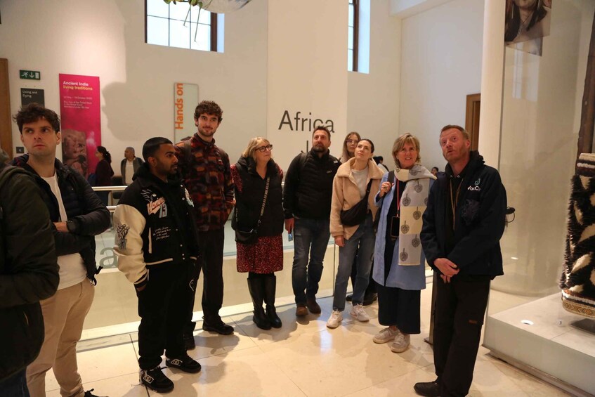 A group of people standing in an indoor exhibition space with a wall labeled 'Africa'. 4
