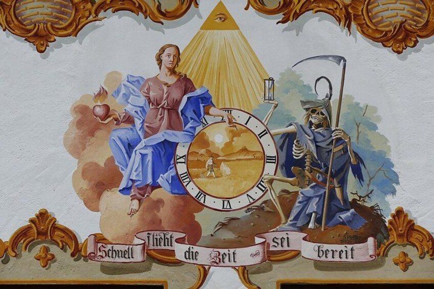 Un mural con una mujer sosteniendo una manzana, un reloj y un esqueleto con guadaña. 2