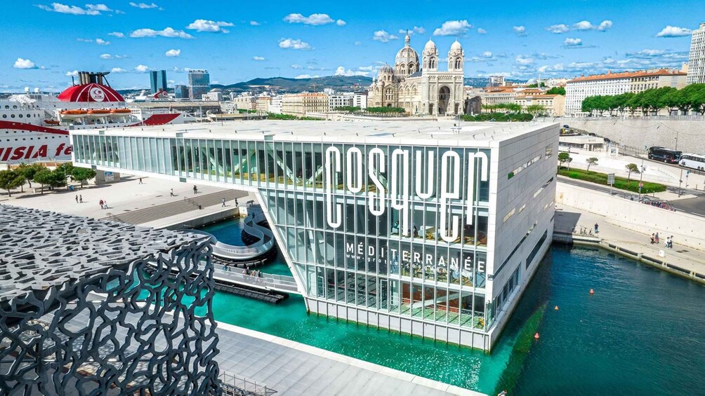 A modern building with the word 'POSTERIOR' on its facade, a pool, and a cruise ship in the background. 1