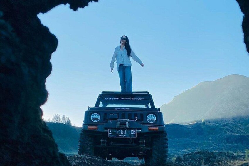 Una persona parada sobre un vehículo con placa Z 1188 CB, rodeada por un paisaje montañoso. 3