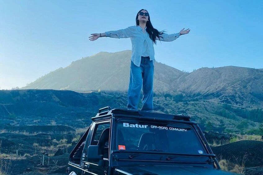 Una persona de pie en un vehículo, con un paisaje montañoso al fondo. 4