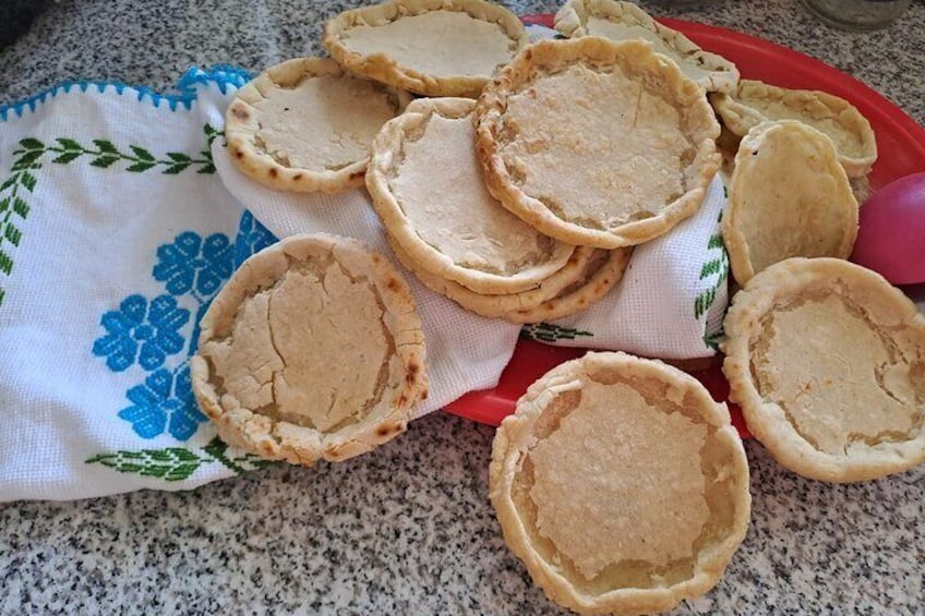 Una colección de costrados de tarta sin hornear sobre una bandeja roja y un paño blanco con motivos florales azules. 1