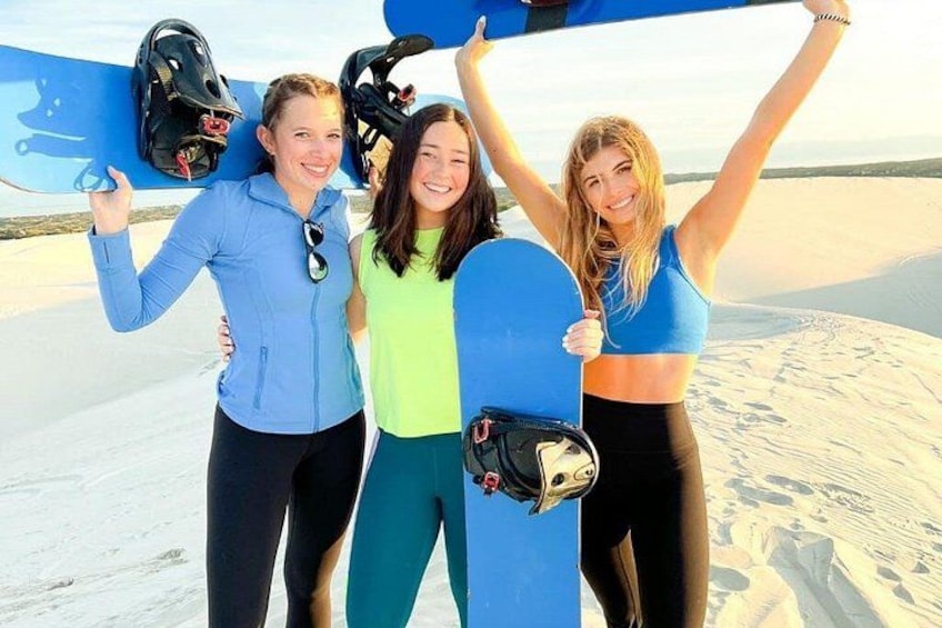 Three people holding snowboards on a snowy landscape. 1