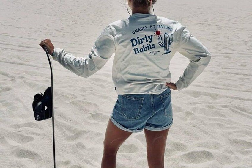 A person standing on a sandy beach holding a fishing rod. 5
