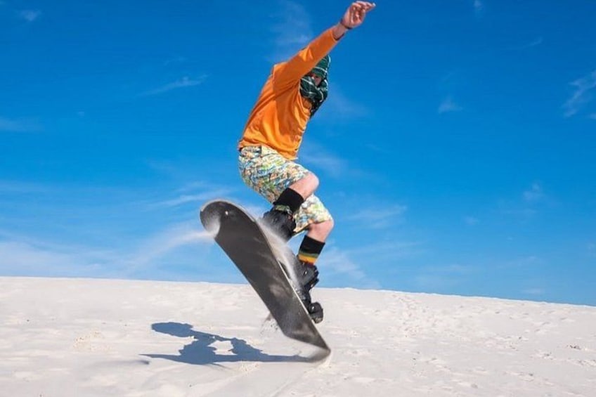 A person snowboarding on a snowy slope under a clear blue sky. 2