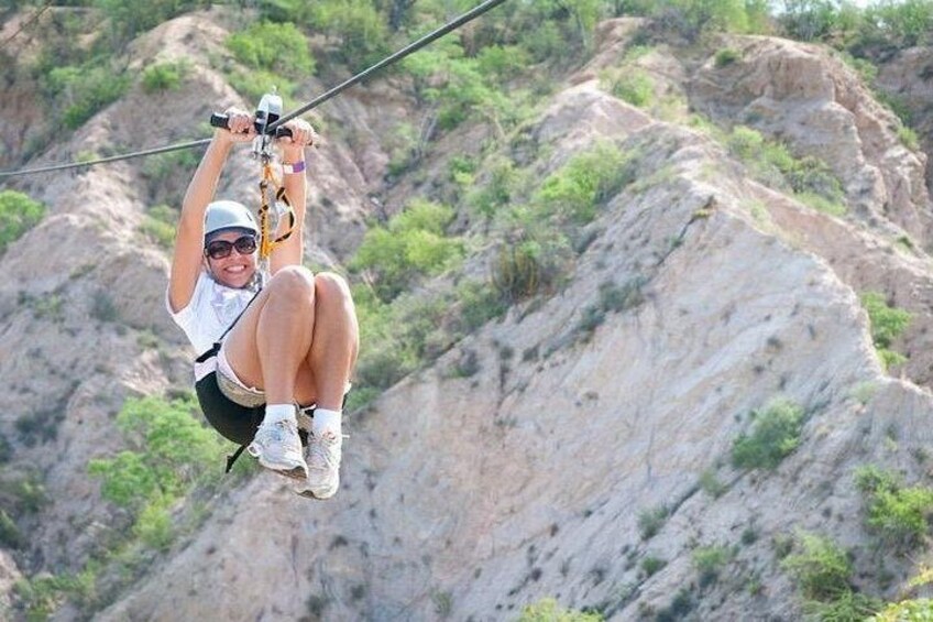 A person zip-lining over a rocky landscape. 1