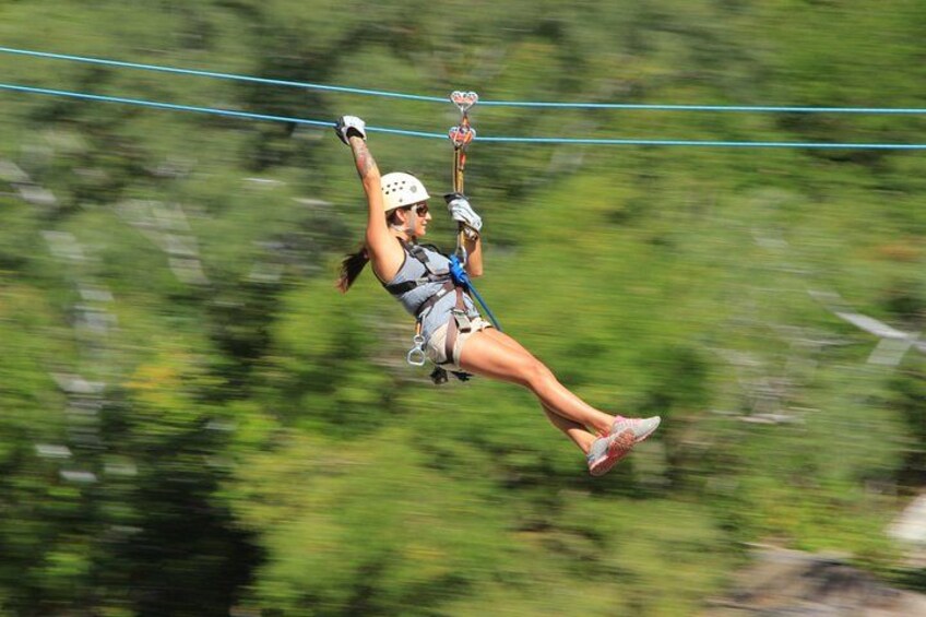 A person zip-lining through a forested area. 2