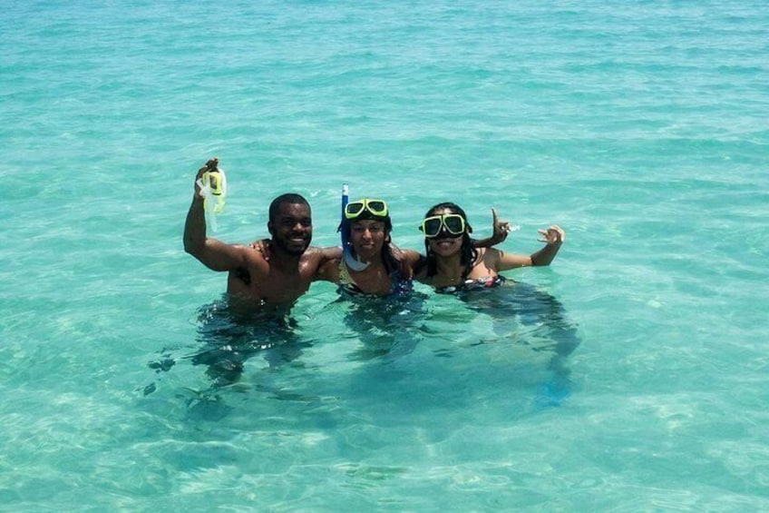 Tres personas haciendo snorkel en aguas turquesas cristalinas. 5