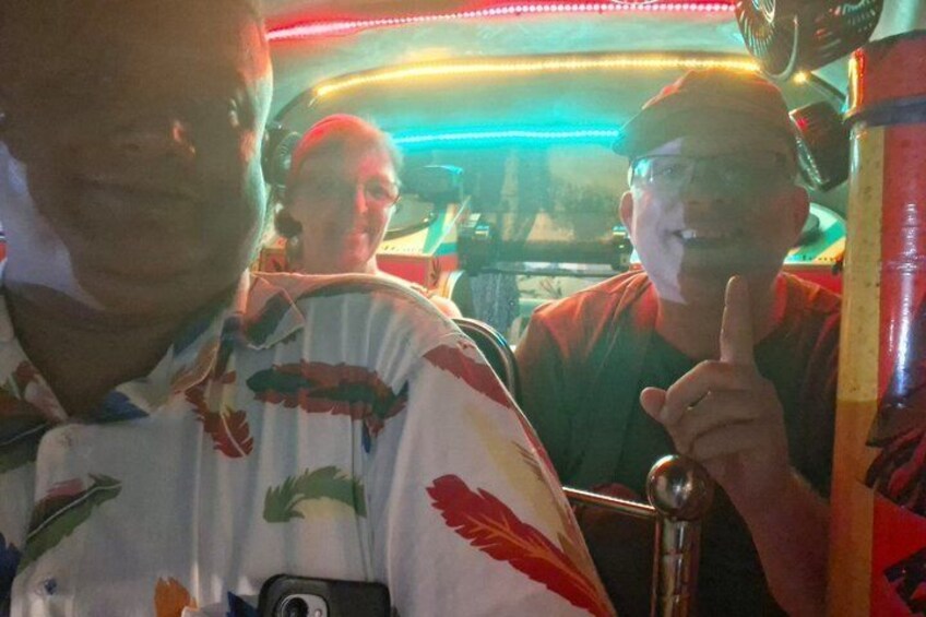 A vehicle interior with colorful patterns and a person making a peace sign. 5