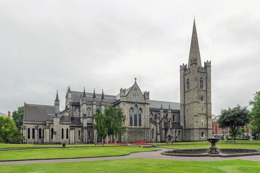 A historic church with a tall spire and a well-maintained lawn in front. 1